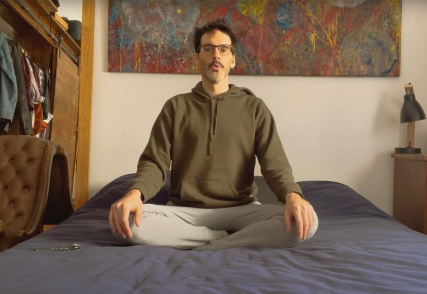 Hombre sentado en su cama meditando