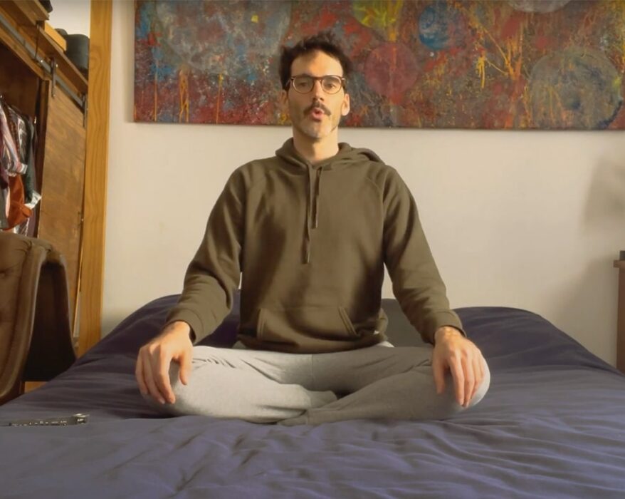 Hombre sentado en su cama meditando