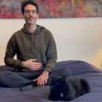 Hombre sentado en su cama meditando