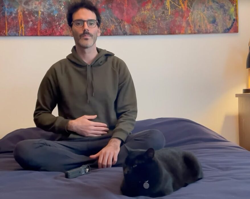 Hombre sentado en su cama meditando