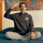 Hombre sentado en su cama explicando