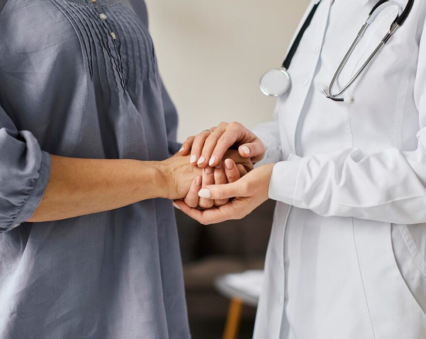 Doctor and patient holding hands