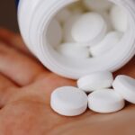 Mano con pastillas blancas