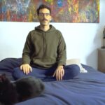 Hombre sentado en su cama meditando