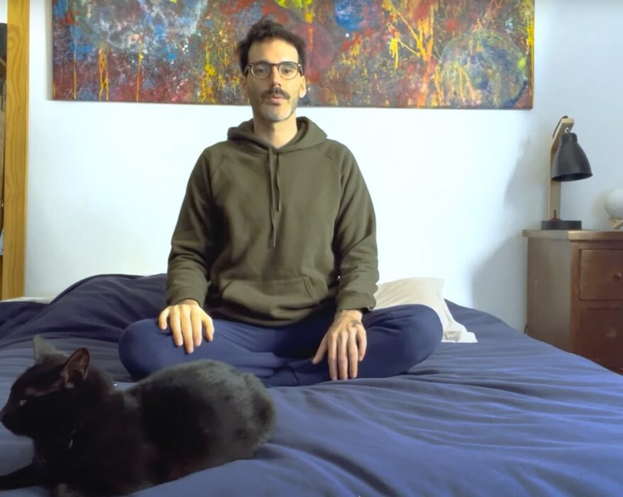 Hombre sentado en su cama meditando