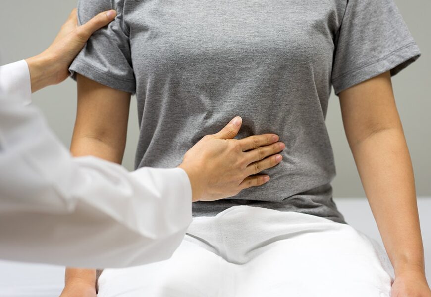 Doctora examinando el abdomen de paciente mujer