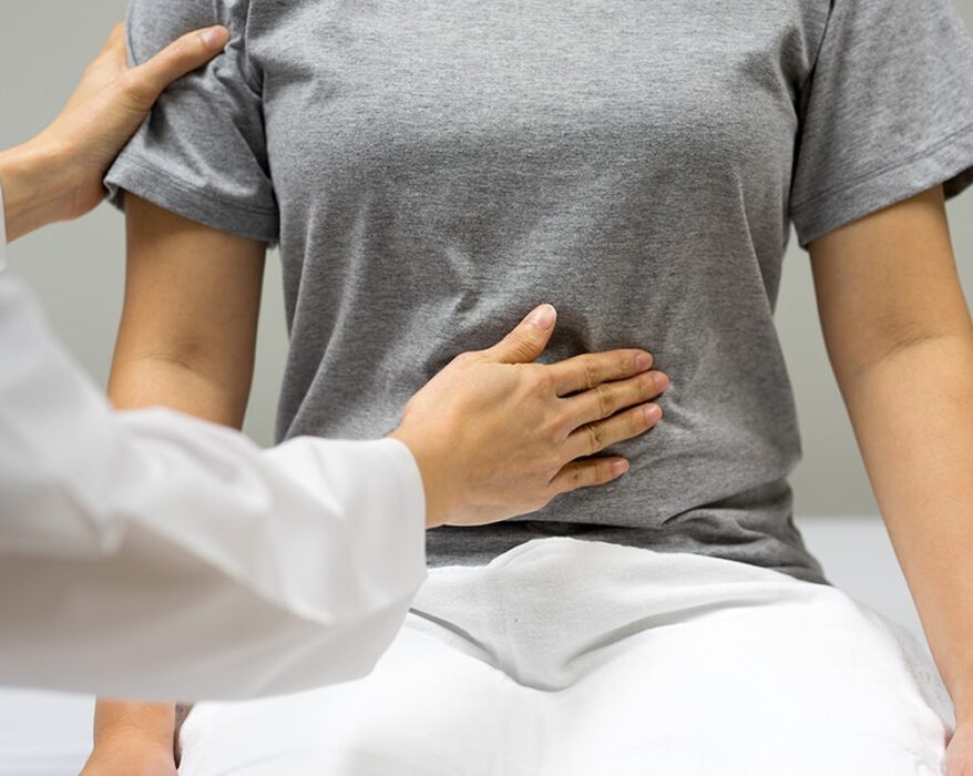 Doctora examinando el abdomen de paciente mujer