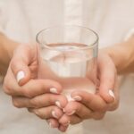 Mujer agarrando un vaso de agua