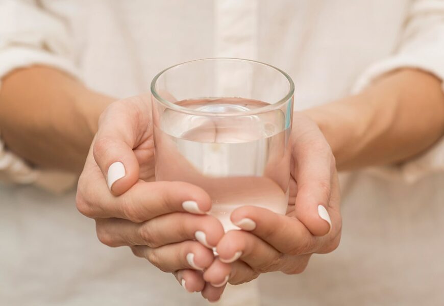 Mujer agarrando un vaso de agua