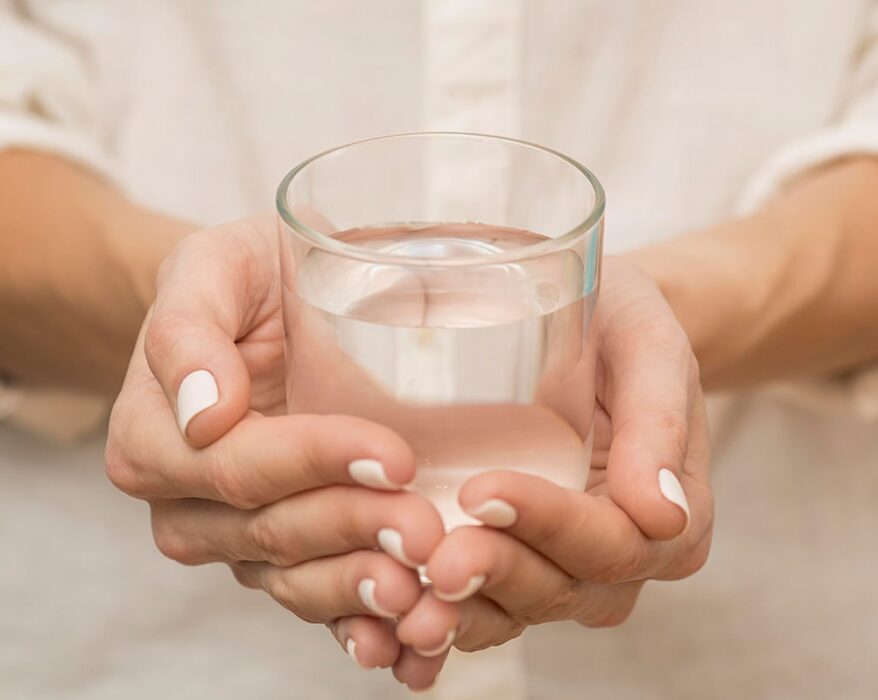 Mujer agarrando un vaso de agua