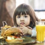 Niña comiendo una hamburguesa