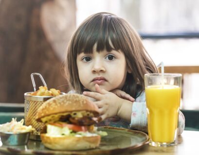 Niña comiendo una hamburguesa