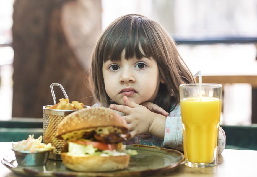Niña comiendo una hamburguesa
