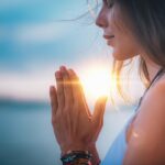 Mujer meditando con sus manos en posición de oración