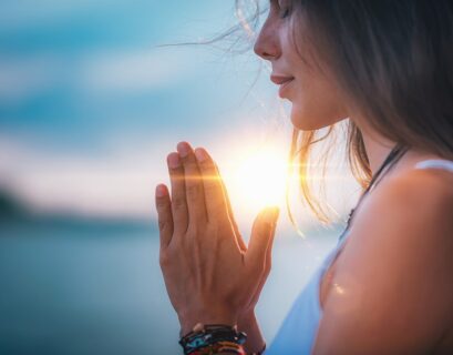 Mujer meditando con sus manos en posición de oración
