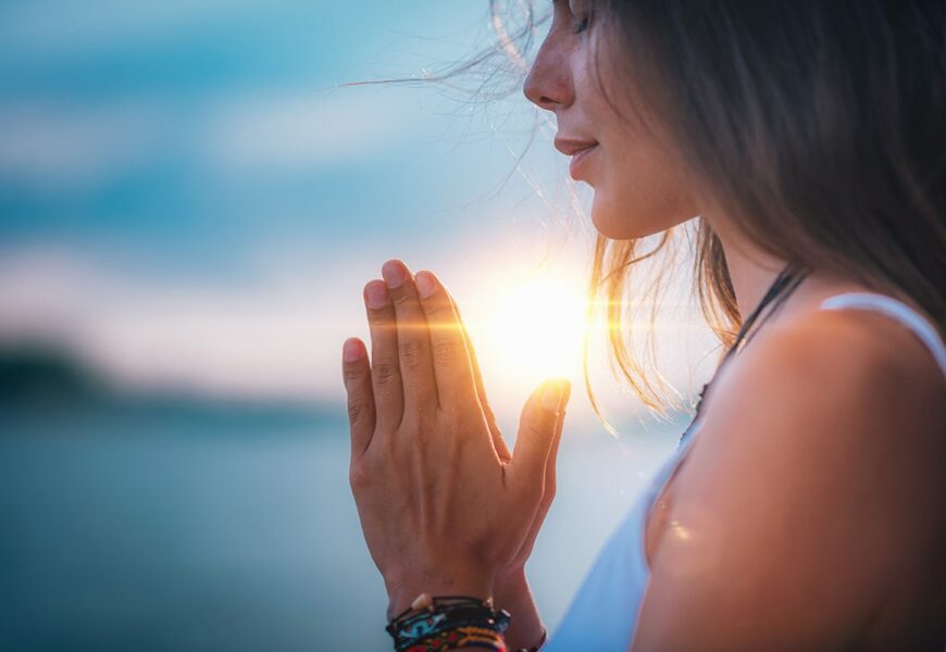 Mujer meditando con sus manos en posición de oración