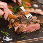 Mujer cortando pedazo de carne