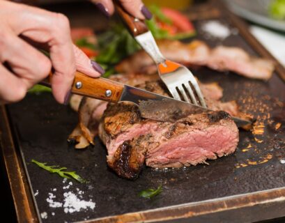 Mujer cortando pedazo de carne