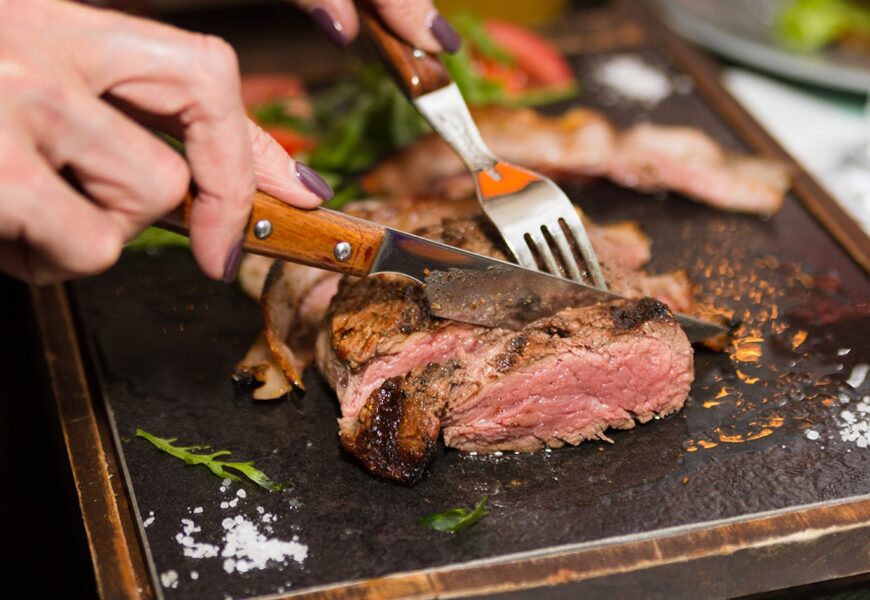Mujer cortando pedazo de carne