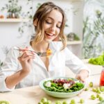 Mujer contenta comiendo ensalada
