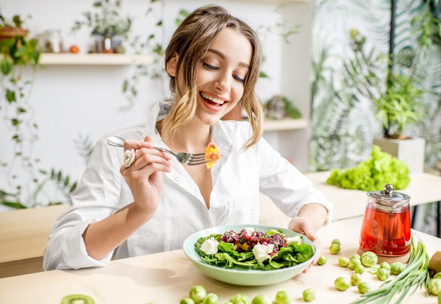 Mujer contenta comiendo ensalada
