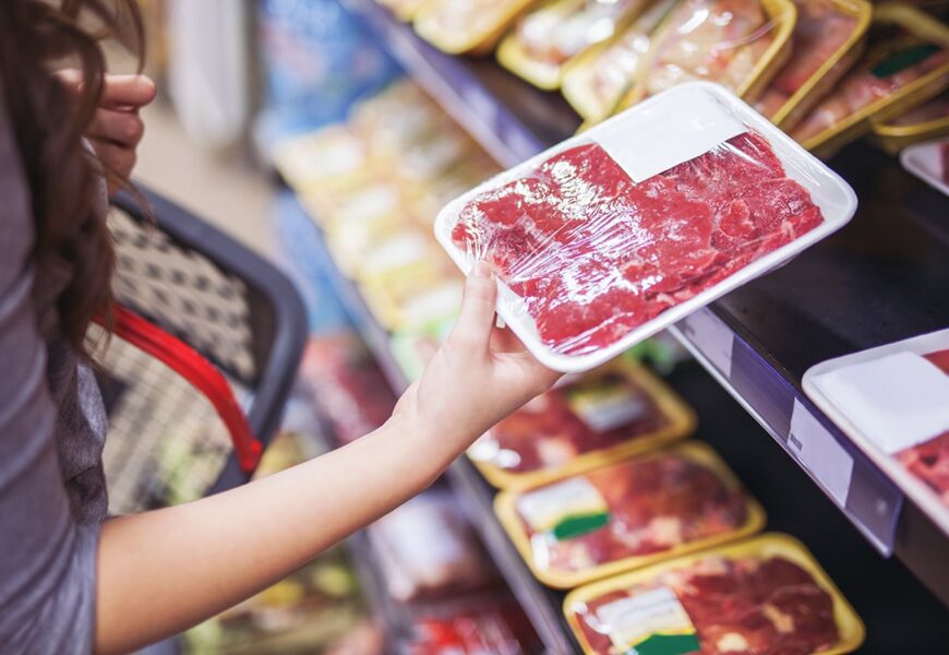 Mujer agarrando carne envuelta en el supermercado