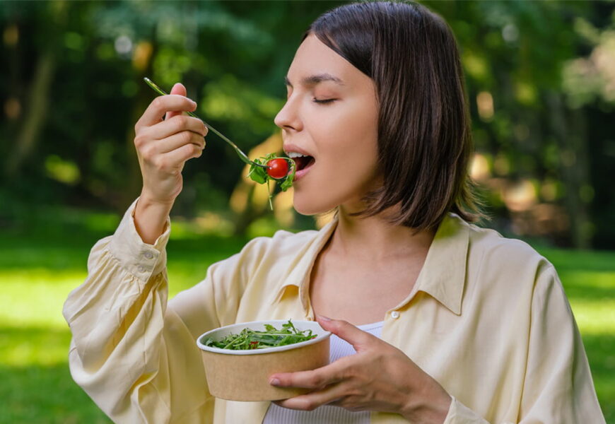 Mujer comiendo una ensalada en la naturaleza